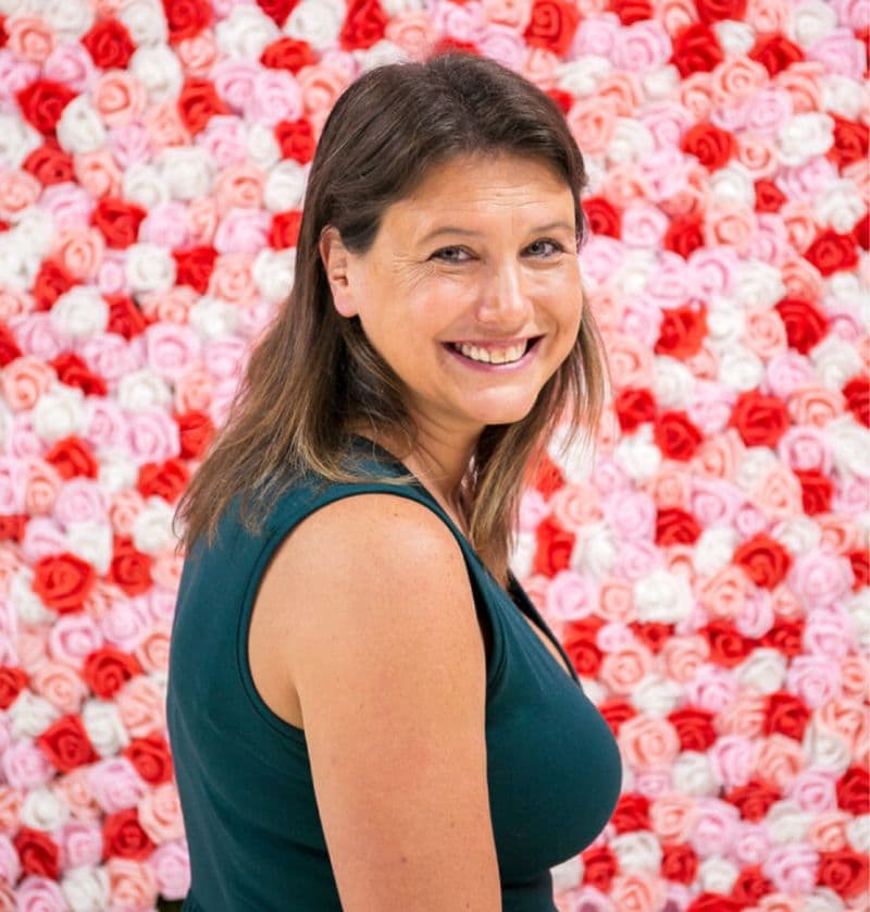 Jess Laverde in front of a wall of roses